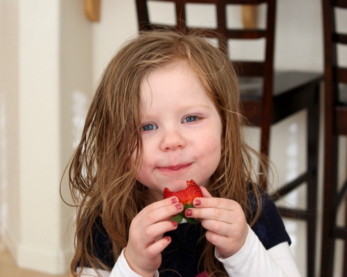 дівчинка їсть полуницю